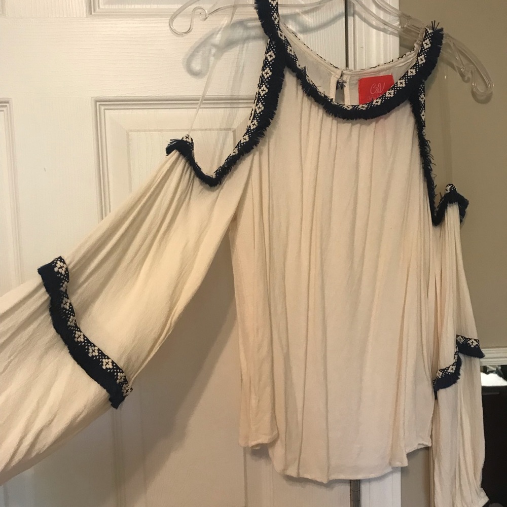 Cold shoulder off white top with navy fringe.